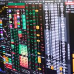Financial charts and market depth data on multiple trading monitors