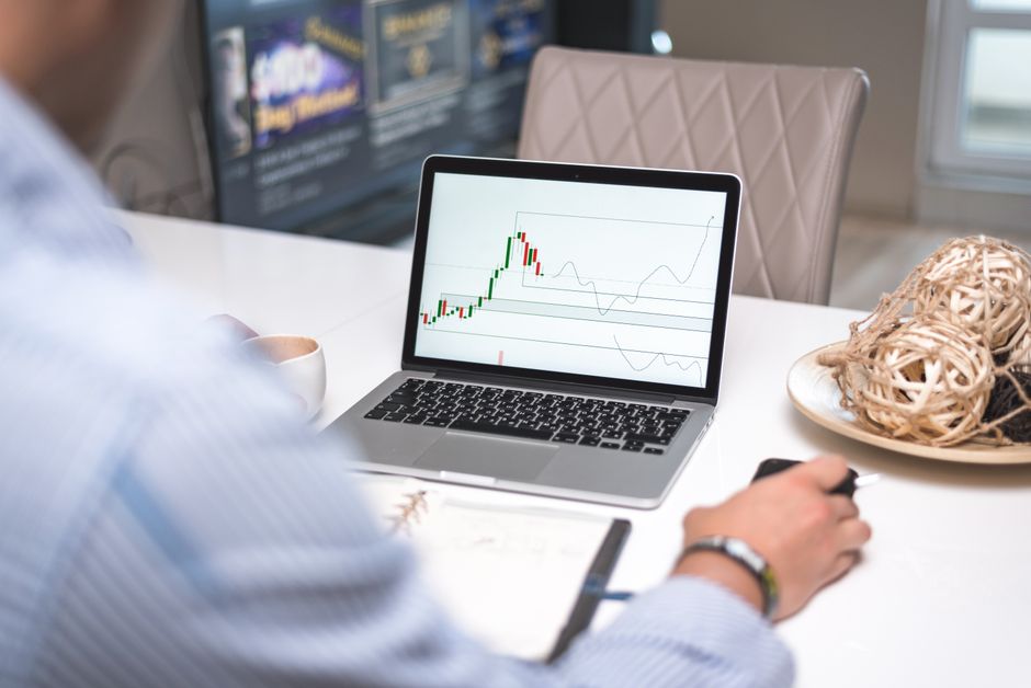 Trader analyzing trade journal and equity curve metrics on a laptop